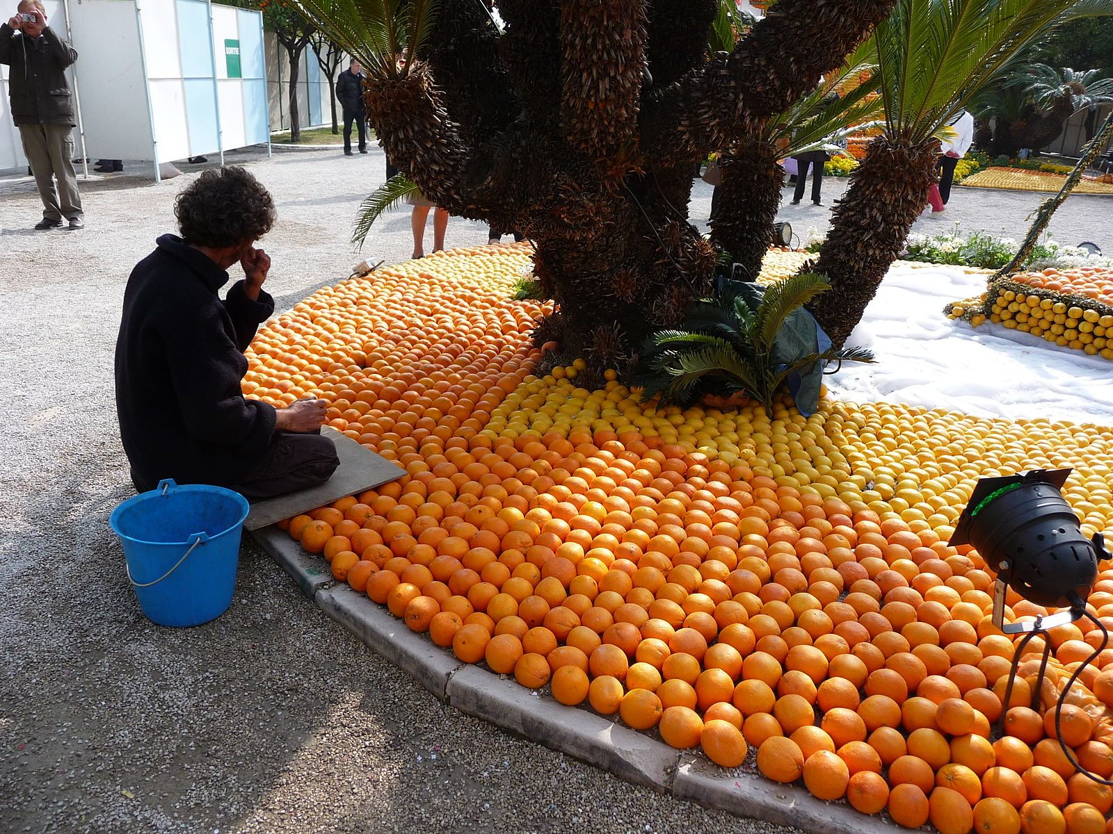 A sculptor replaces a piece of pilfered fruit at the 2013 festival.