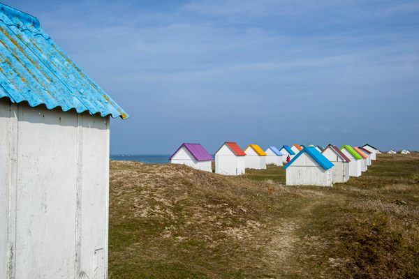 Colorful beach cabins in the dunes at Gouville-sur-Mer.