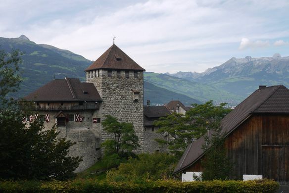 A stone tower with brown pointed roof surveys a mountainous valley