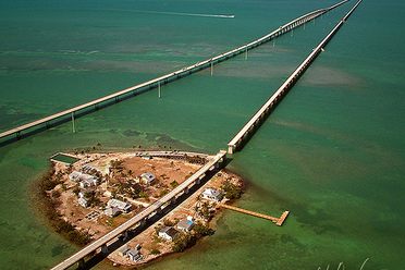Aerial view of Pigeon Key, with the partially decimated Overseas Railroad bridge running parallel to the new Seven Mile Bridge. 