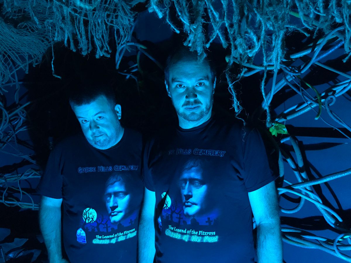 Yu and Bolton pose in front of their creation, wearing shirts that Bolton designed.
