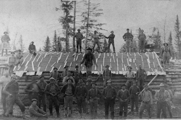 A group of men pose at Russell Camp, another camp for loggers in Maine, circa 1900.