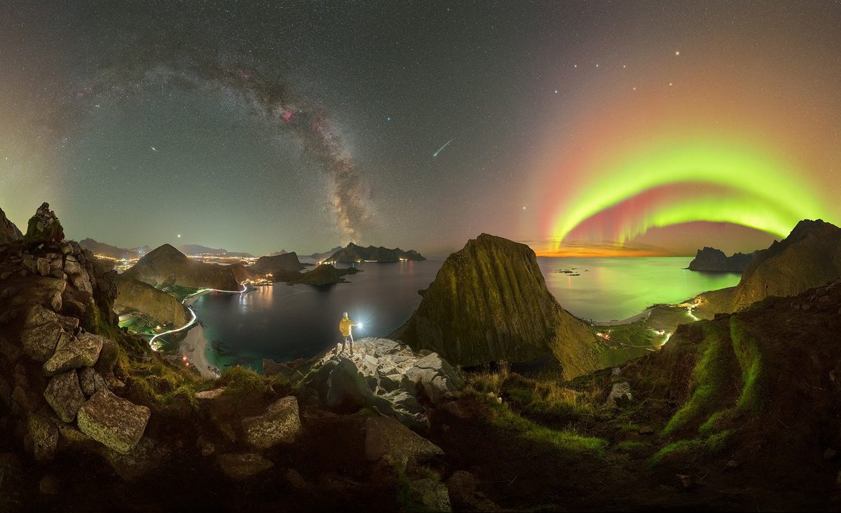 A panoramic view from one of the jagged peaks of Arctic Norway’s Lofoten Islands offers an endless array of treats for the eye, from the Milky Way to a double rainbow–like arc of auroras. There’s even a shooting star in the center of the image, the Andromeda galaxy visible under the Milky Way, and, for good measure, the lingering light of a setting sun below the auroras.