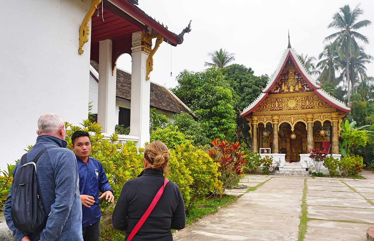 Two tourists listen to an Orange Robe Tours guide.