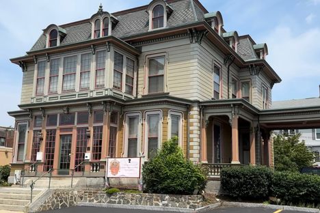 A large Victorian mansion with many windows.