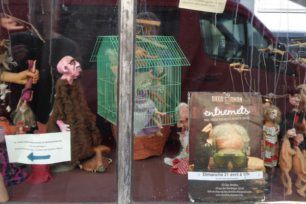 Papier-mâché puppets in the storefront.