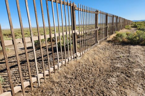 Perspective view, looking southerly, of one of the wooden slat fence surrounding one of the 1-square mile arrays.