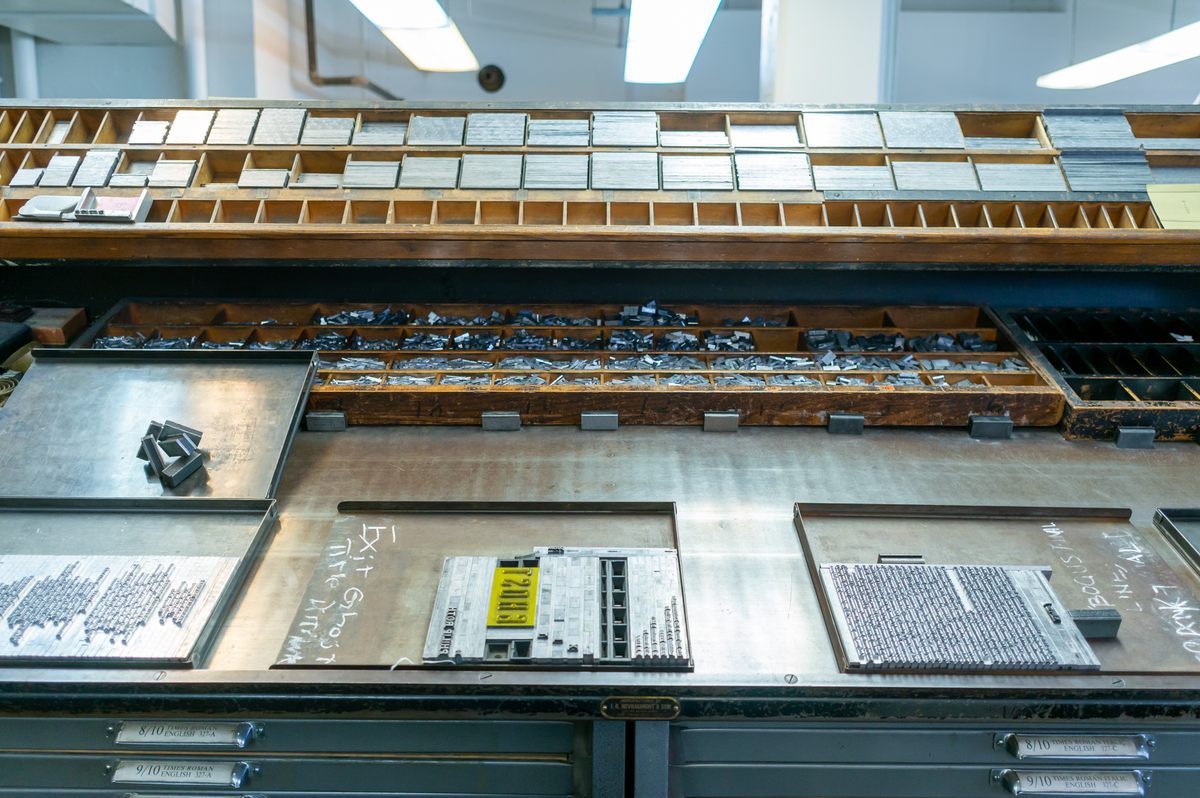 A typical composing area for handset type: The tilted workspace with a lip at the bottom can hold type cases (cabinet drawers) or the trays (“galleys”) shown here.