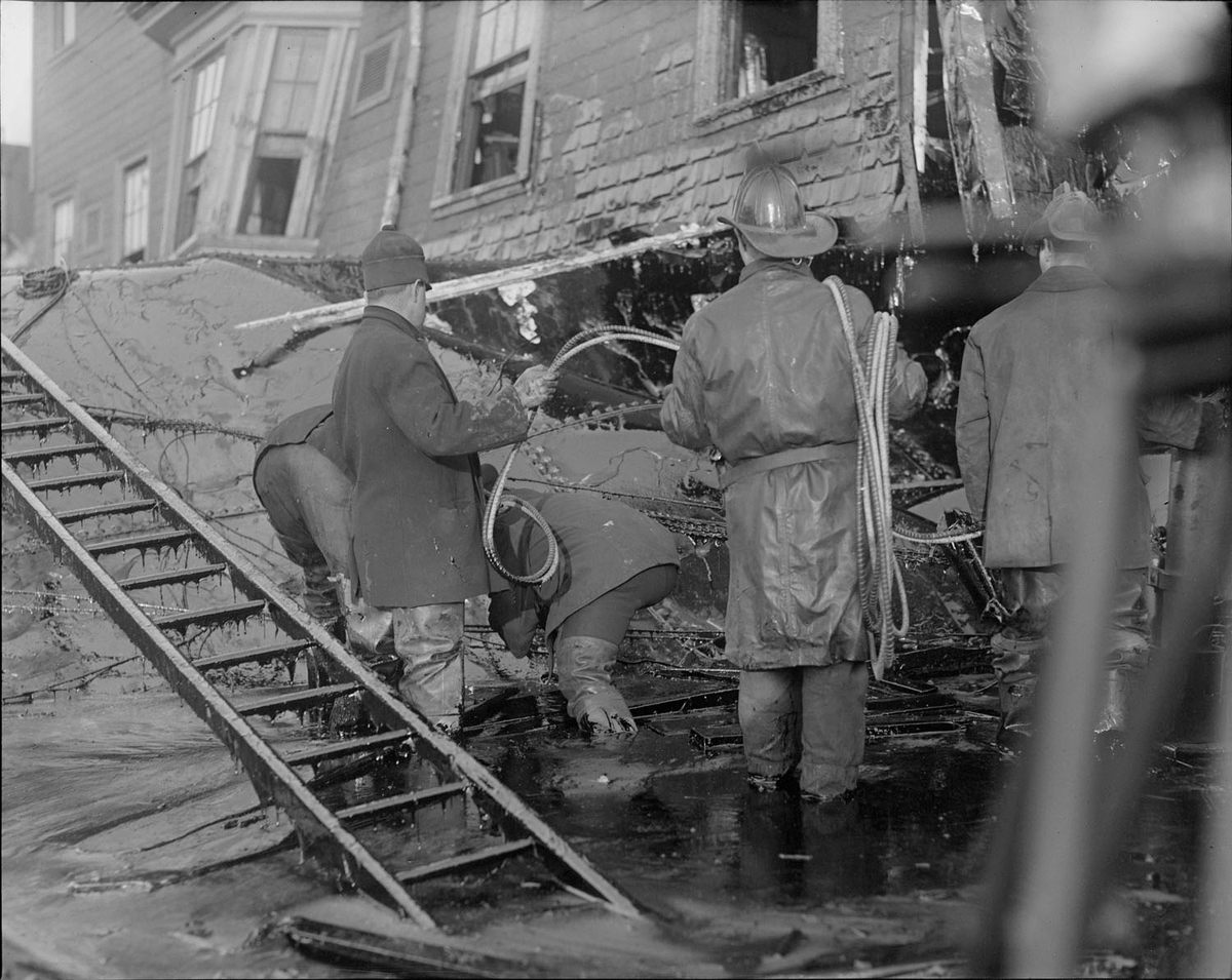 Firemen standing in thick molasses after the disaster.