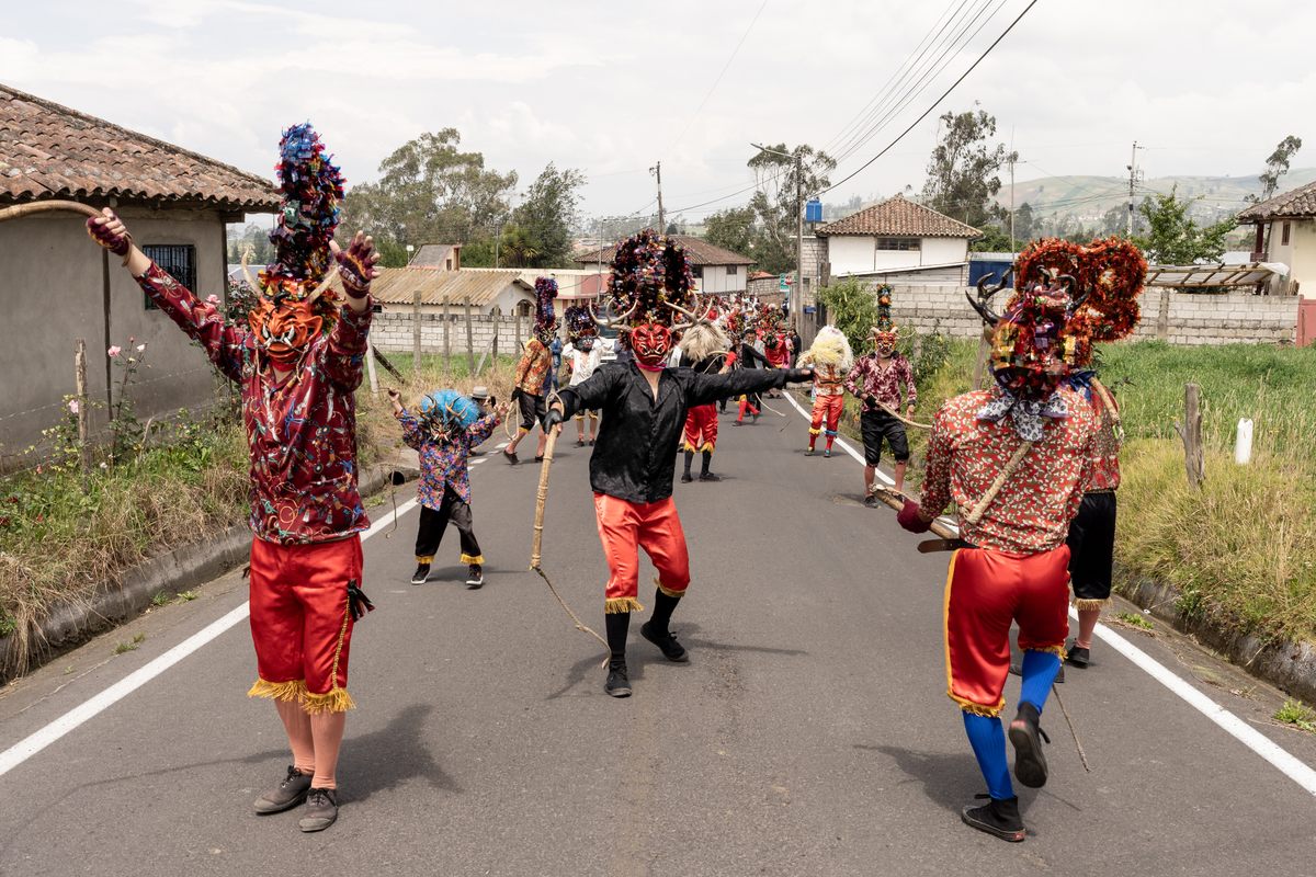 The devils of the Minga Tunguipamba head towards the center of Píllaro on the first day of the Diablada of 2023. The devils dance, crack their whips, and yell "Banda!"—a demand for the band to keep playing.