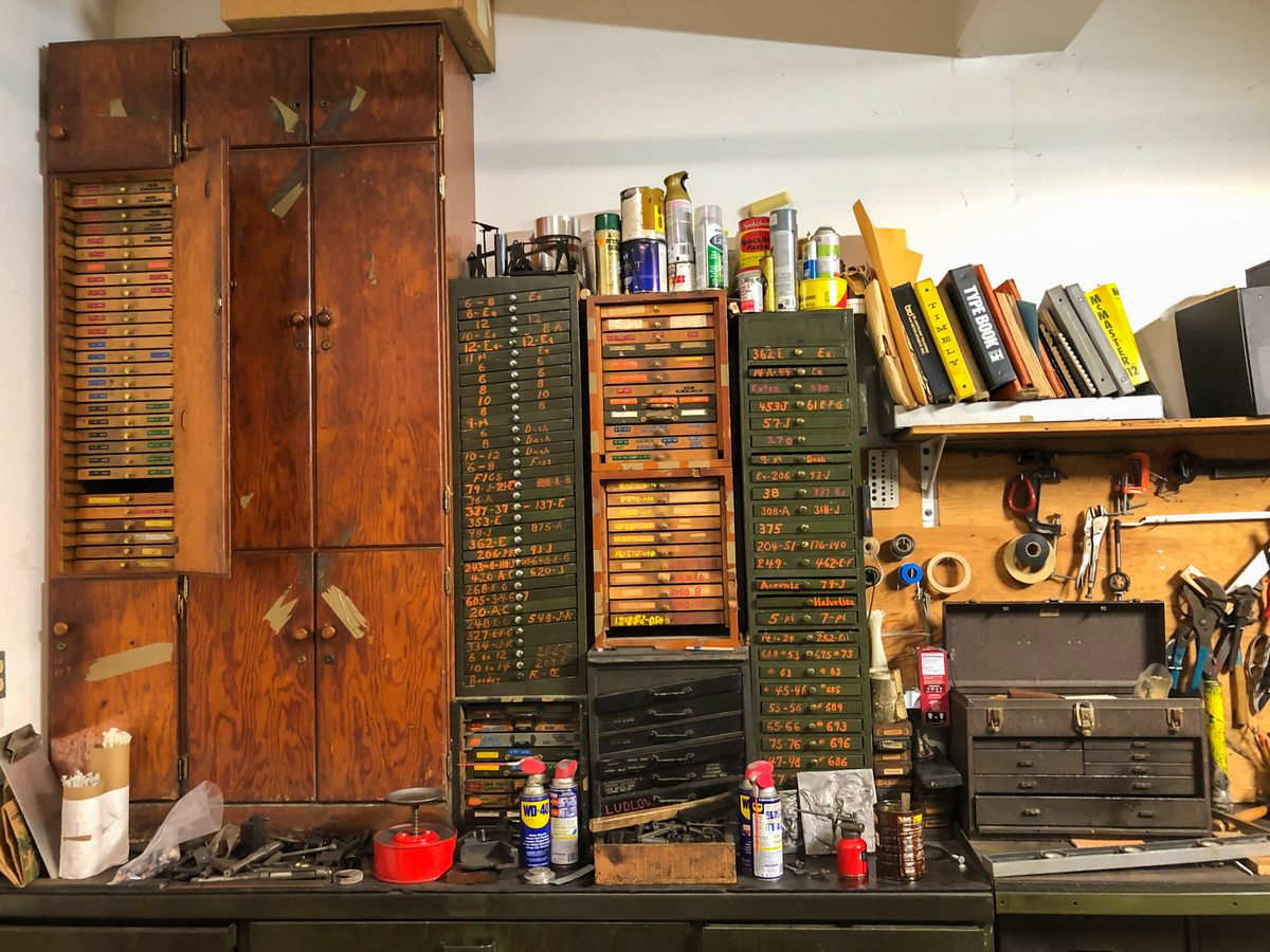 Cabinets and drawers hold type matrices for casting metal type alongside a portion of the tools and materials required to keep the historic equipment up to snuff.