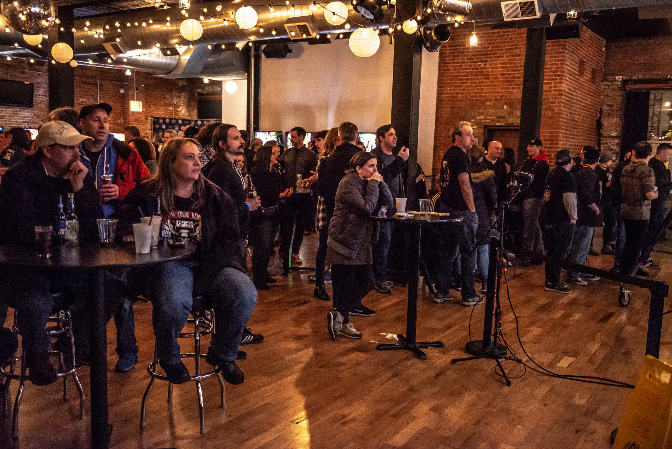 Competitive pinball is a spectator sport, too. Jim Belsito (center right, with hand in his pocket) watches his competitors.