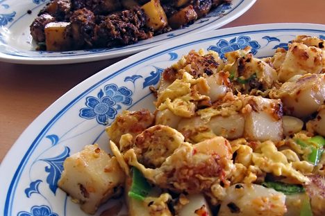 Black (in the background) and white carrot cake, served with peanuts and scallions.