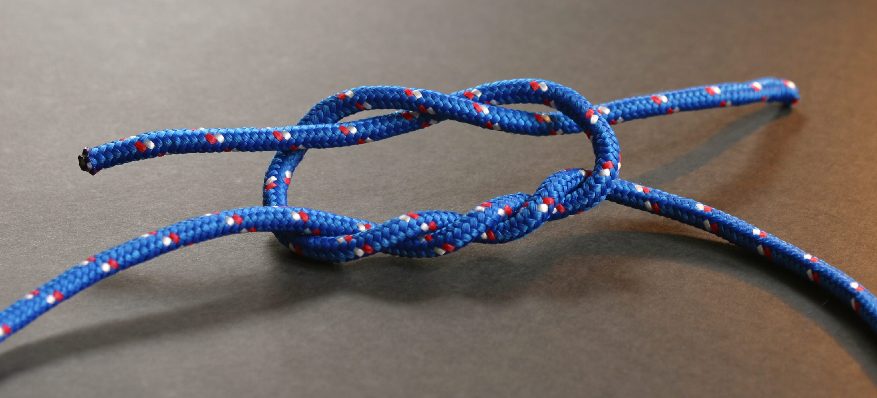 A surgeon's knot in the process of being tied.