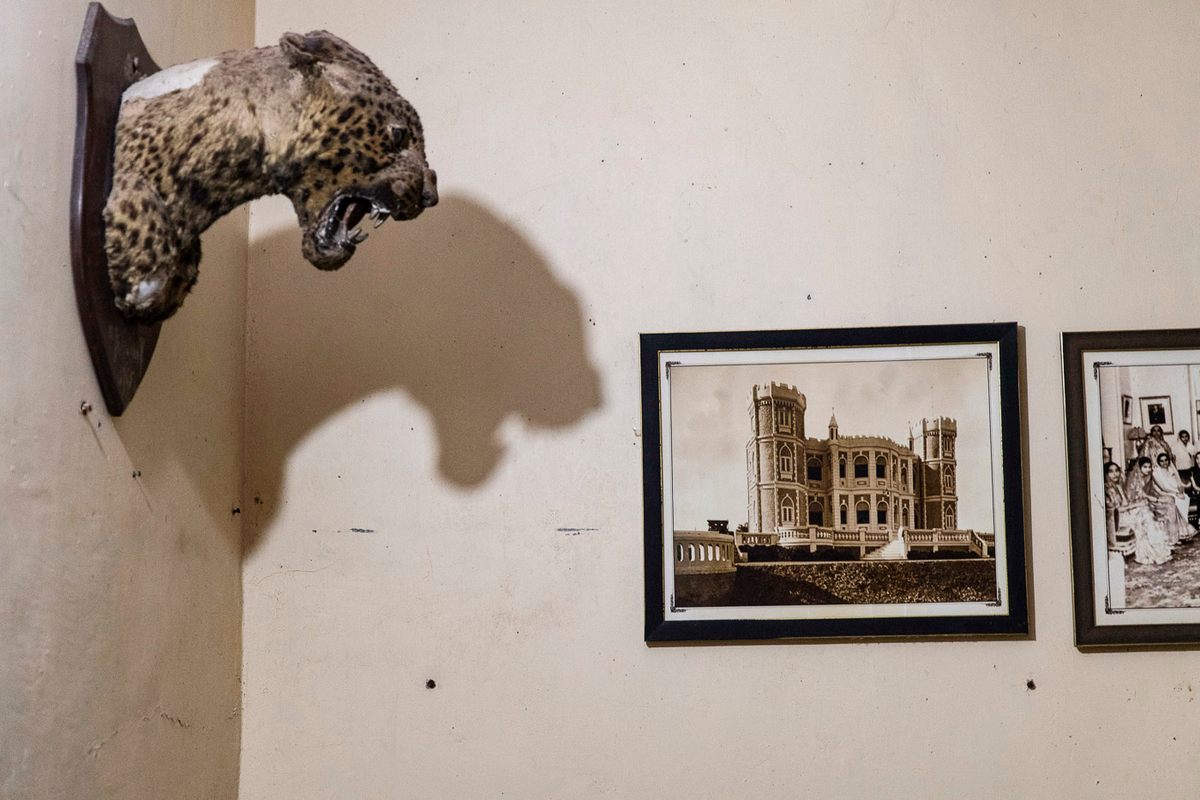 Taxidermy heads guard the campus bedrooms. The photo on the wall shows the royal residence that used to stand on the Gujarat site.