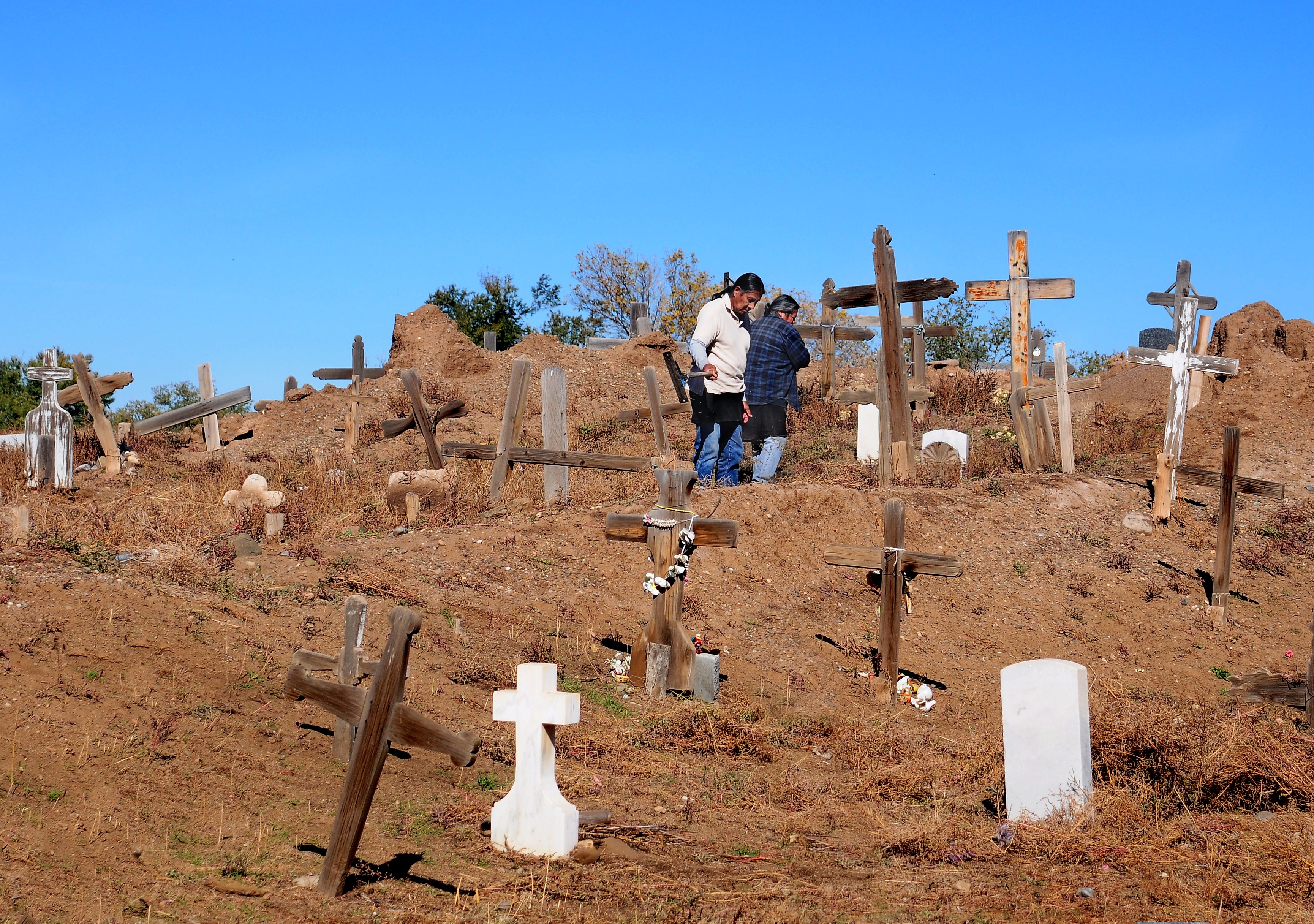 Two Taos Pueblo men tend to their community cemetery in New Mexico.