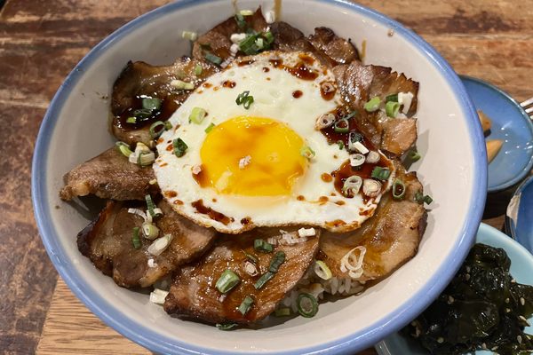 Thinly sliced char siu topped with a runny-yoked egg.