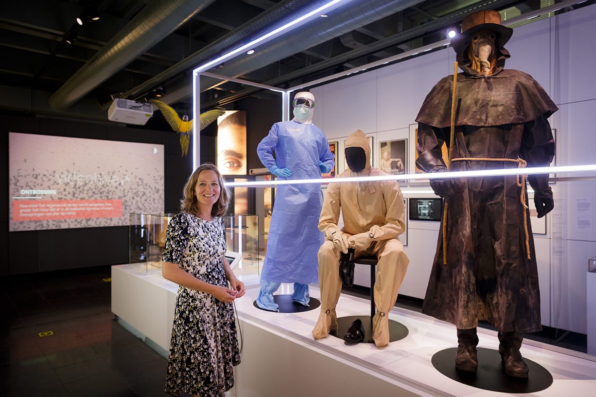 Curator Mieneke te Hennepe stands beside medical suits dating centuries apart in a section of the exhibit dedicated to treatments.