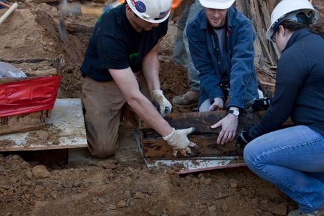 Contractors help unearth a coffin at the 218 Arch Street construction site in Philadelphia. 