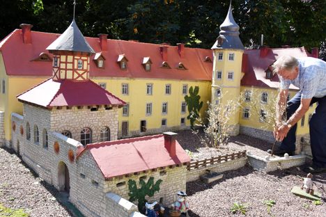 Günther Beinert straightens a mini tree beside one of his 1:10 castles.