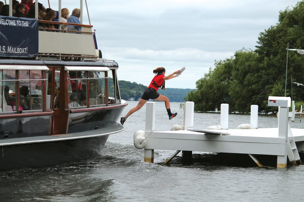 More than 100 passengers watch as Jessa Burling leaps across the waters of Lake Geneva to deliver the mail.