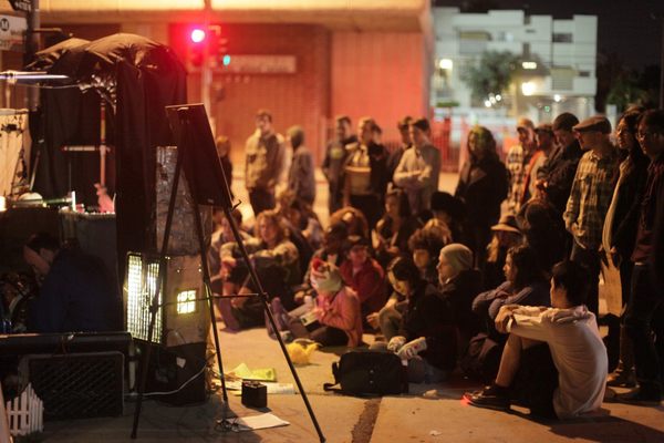 A crowd gathers streetside for a monthly service