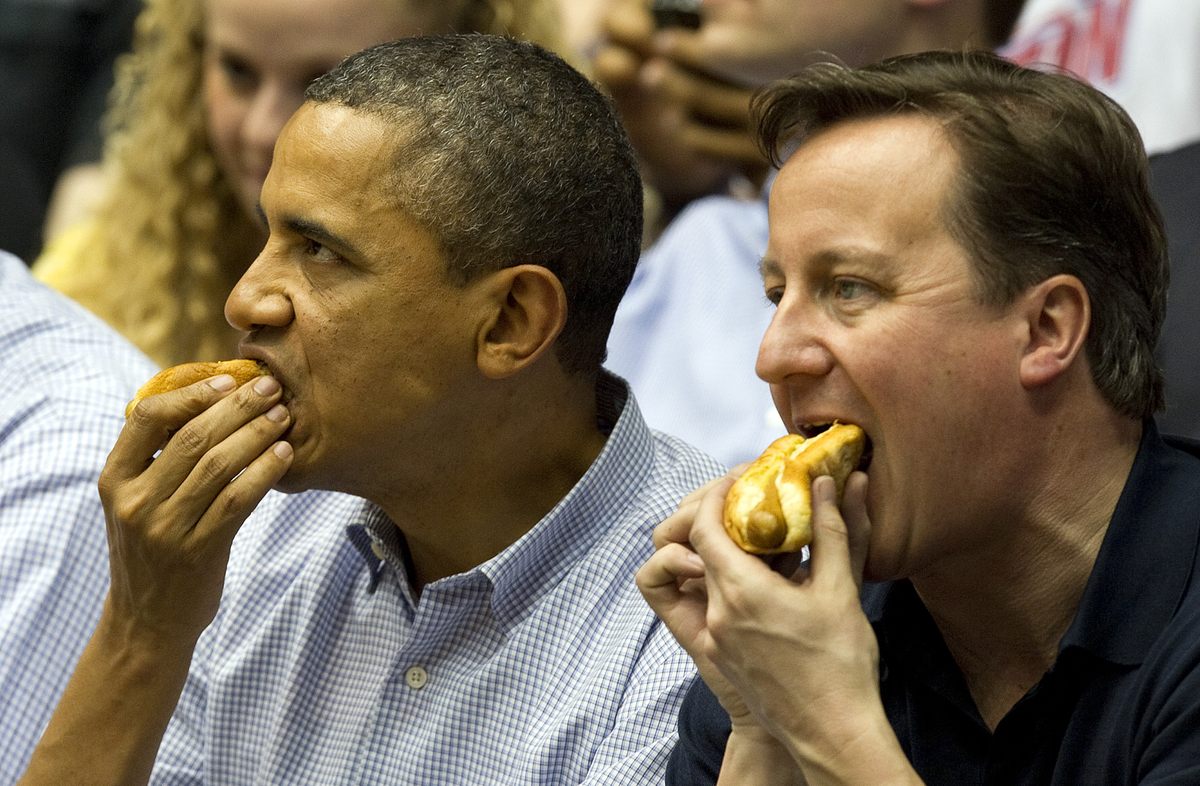 President Barack Obama and British Prime Minister David Cameron eat hot dogs at the NCAA basketball tournament in 2012