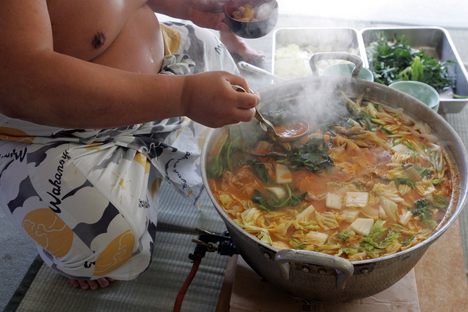 A sumo wrestler dishes up chanko-nabe during a "Sumo Diet Campaign" event in Osaka, Japan.