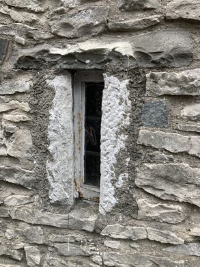 a small vertical window surrounded by a stone wall