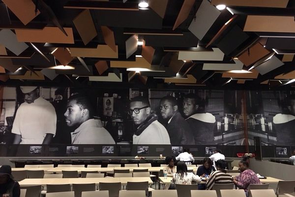 An image of the Greensboro Woolworth lunch counter sit-in illuminates the cafe interior.