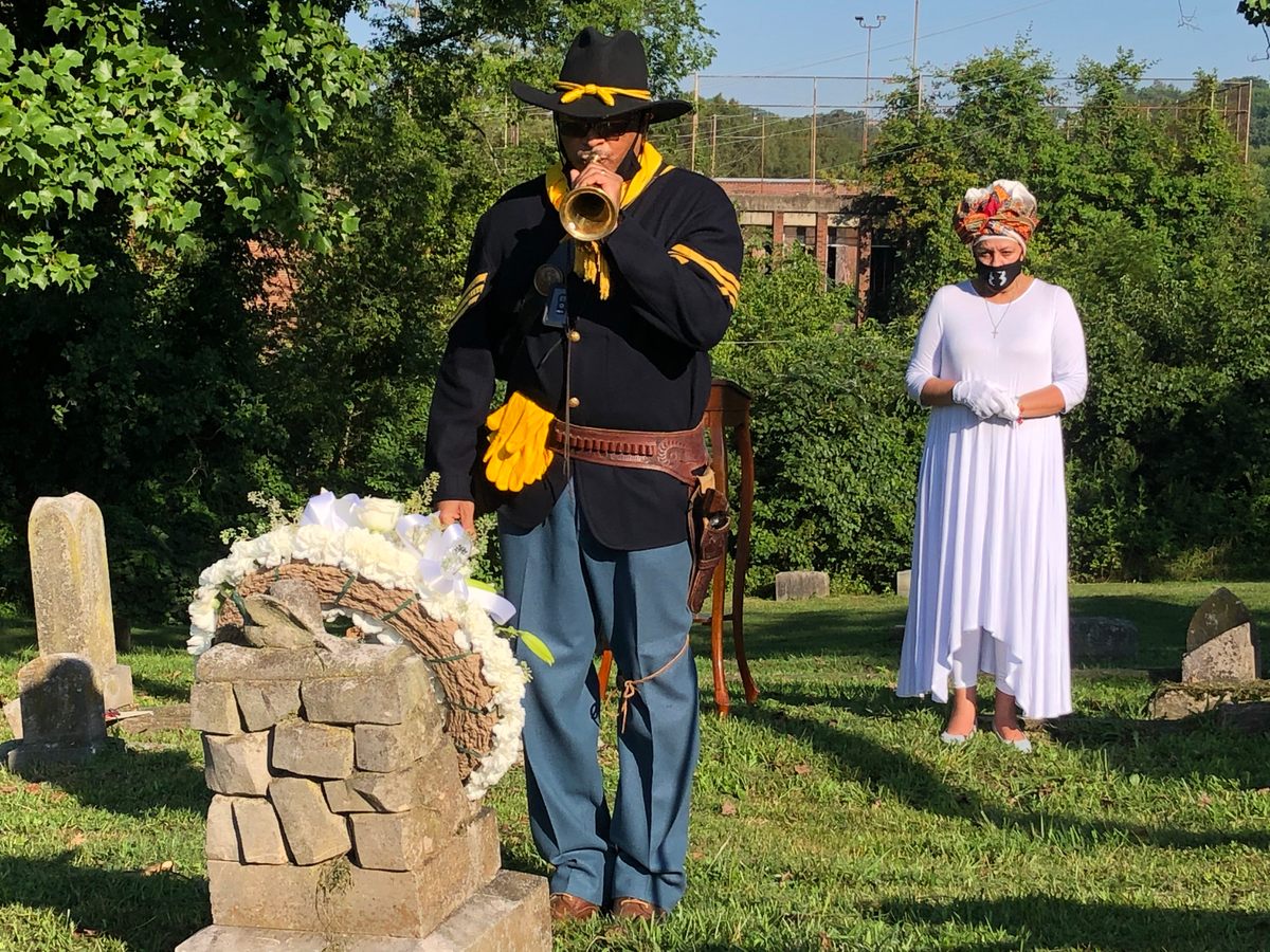 A man dressed as a Buffalo Soldier over the grave of Lizzy Forby.