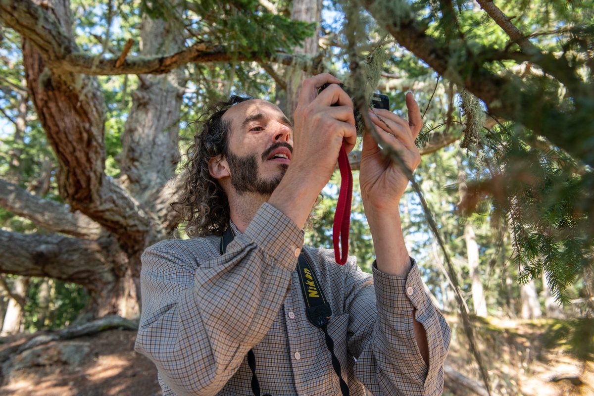 Naturalist Andrew Simon uses the macro lens on his camera to inspect the minute details on a sample of lichen.