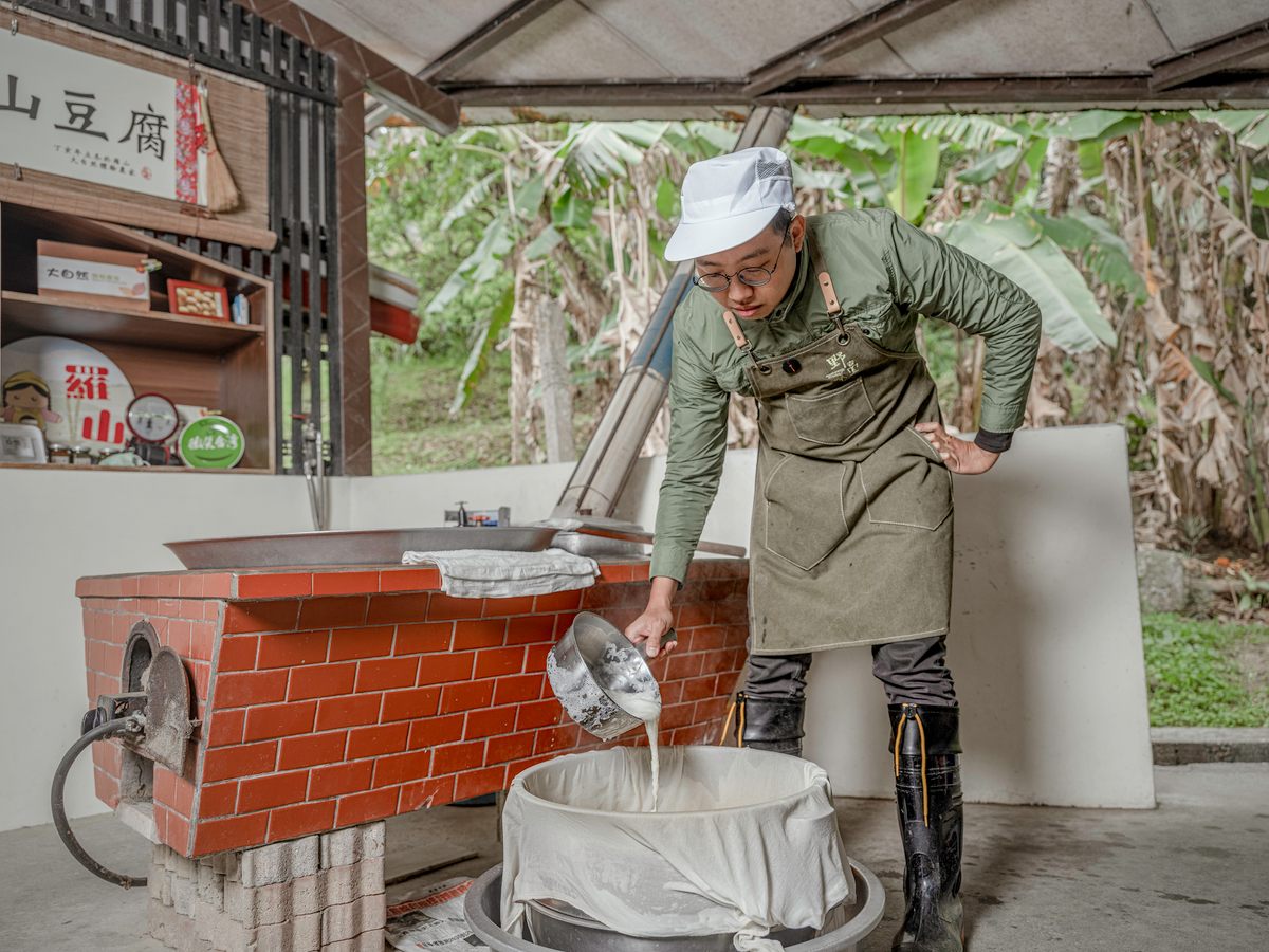 Chang Shun-Hsing pours the soy milk to filter it.