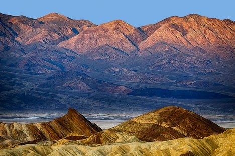 The sun rises on the badlands of Death Valley National Park. On a summer morning, the temperature may already be over 100 degrees. 