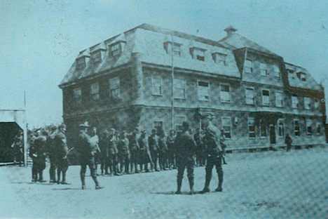 Army drills in front of the Crown Hotel. Designed by W.C. Harris, architect, this was meant to be the working man's hotel. It was less luxurious but still far above most hotels of the day. In 1916 the 185th Battalion was stationed at Broughton. The town had been deserted, but had fine quarters for the military: officers and the hospital were in the Broughton Arms; the non-commisioned officers at The Crown Hotel; and the enlisted men in the forty-three cottages that had been built for miners.