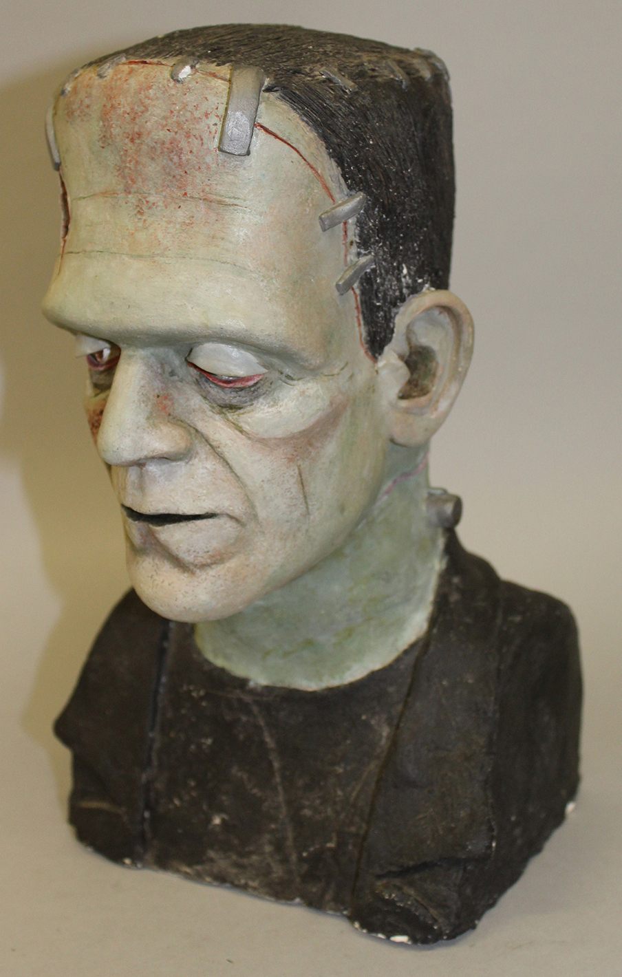 A painted plaster bust of Frankenstein Monster, signed on white label on reverse, 11” high       £50 – 100