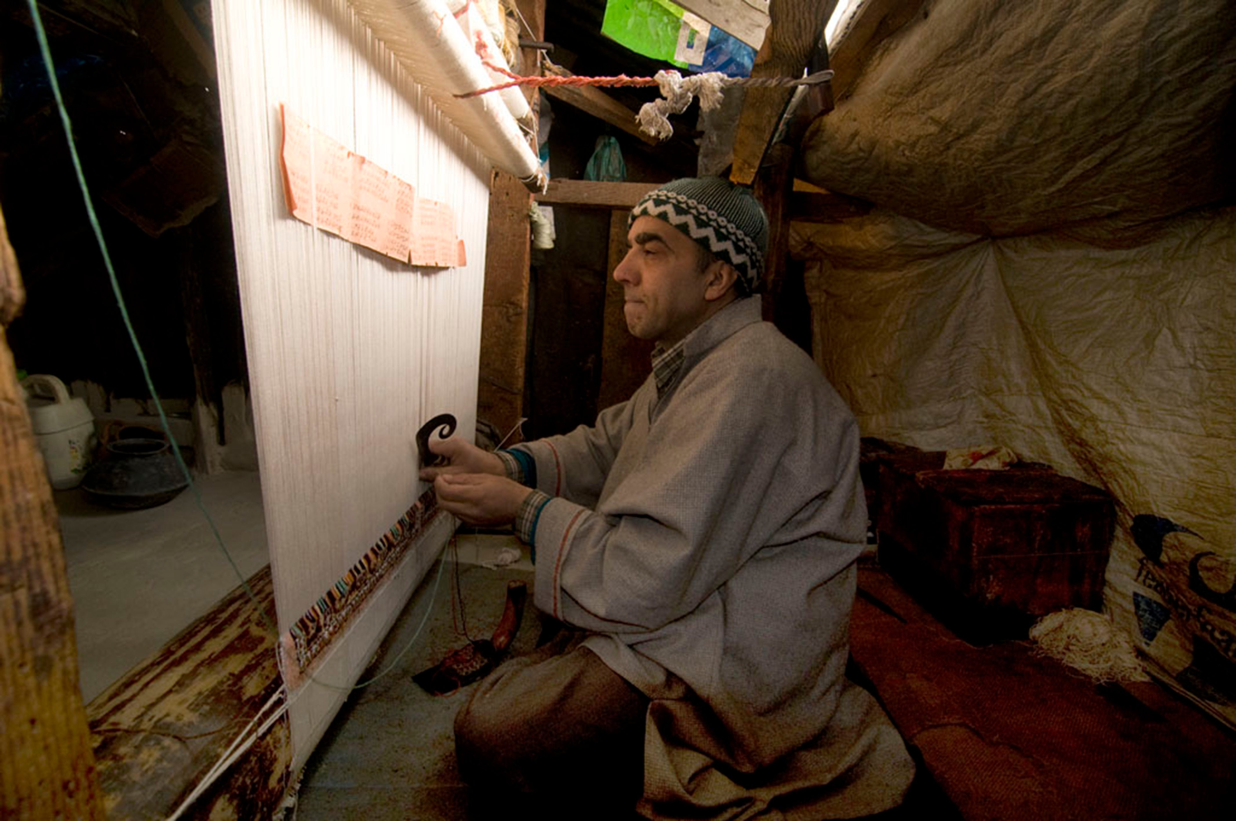 Aslam Khan in his ancestral home in Srinagar, stares at the brown parchment that has the weaving design and color codes.