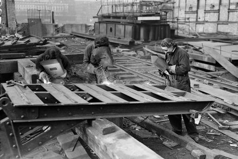 A photo from The Daily Herald, with the original caption "Girl acetylene welders were at their job as usual today, cutting the girders of the temporary Waterloo Bridge, which is being dismantled." 
