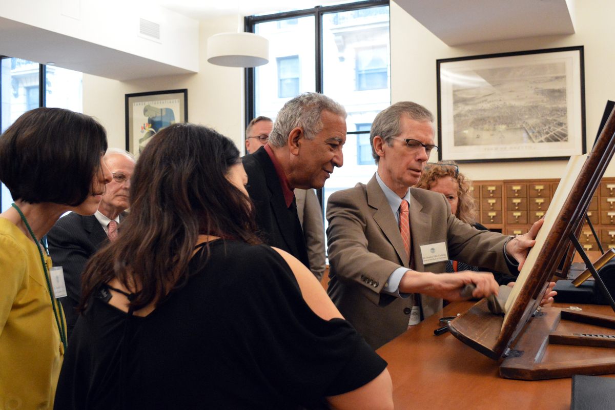 Stanley Ellis Cushing shows off a rare book in the Boston Athenaeum print room.