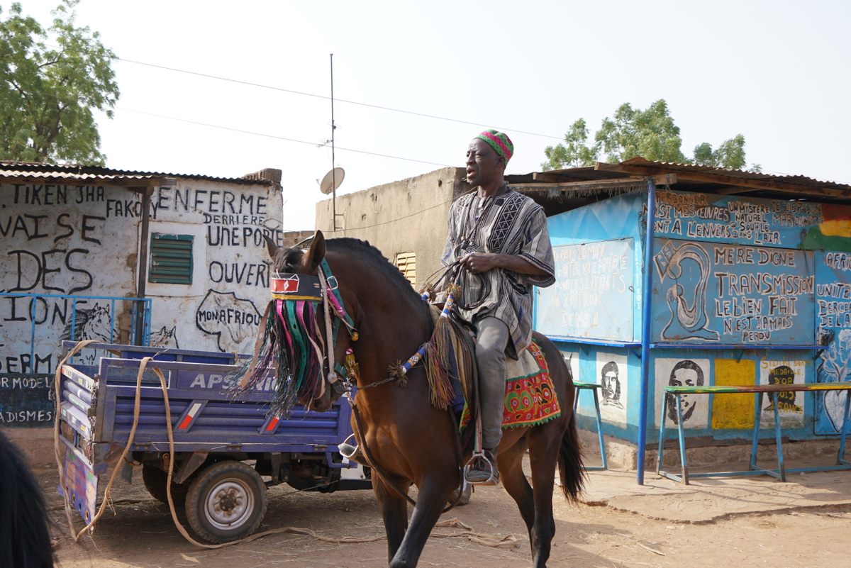 Madi Dermé's uncle, also named Madi Dermé, rides a horse through the neighborhood of Nonsin in Ouagadougou. Caring for these horses has become increasingly difficult with rising unrest in Burkina Faso.