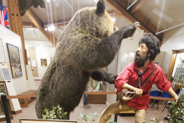 A diorama of Hugh Glass exiting, pursued by a bear.