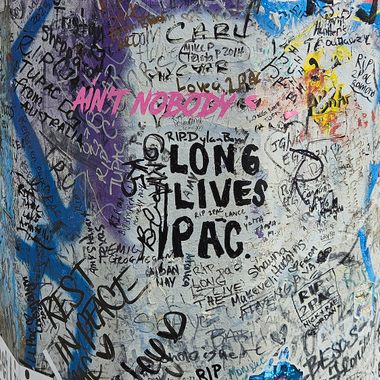 Graffiti on the utility pole pays homage to the late Tupac Shakur.