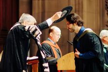 At the University of Edinburgh's graduation ceremony, a student is tapped with the Geneva Bonnet.