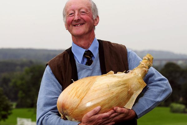 Peter Glazebrook cradles one of his creations, an 18-pound onion that won the world record in 2012. 