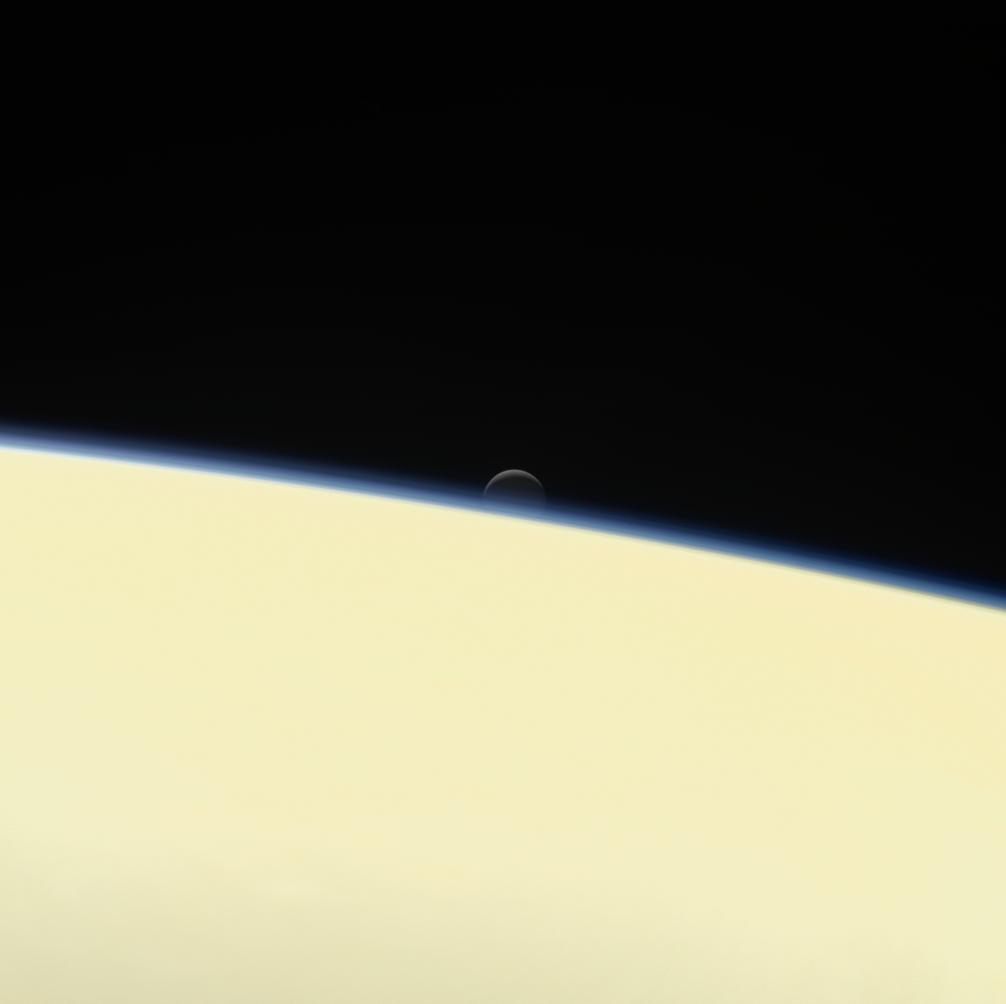 One of <em>Cassini</em>'s last images, showing the moon Enceladus sinking behind the planet, September.