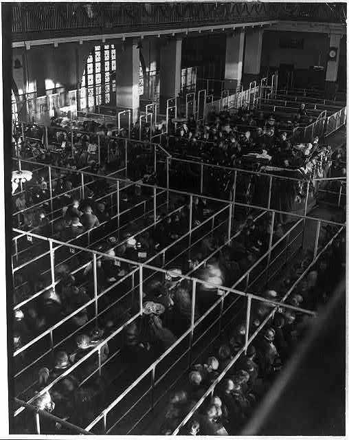 Emigrants in "pens" at Ellis Island, New York, probably on or near Christmas --note the decorations]