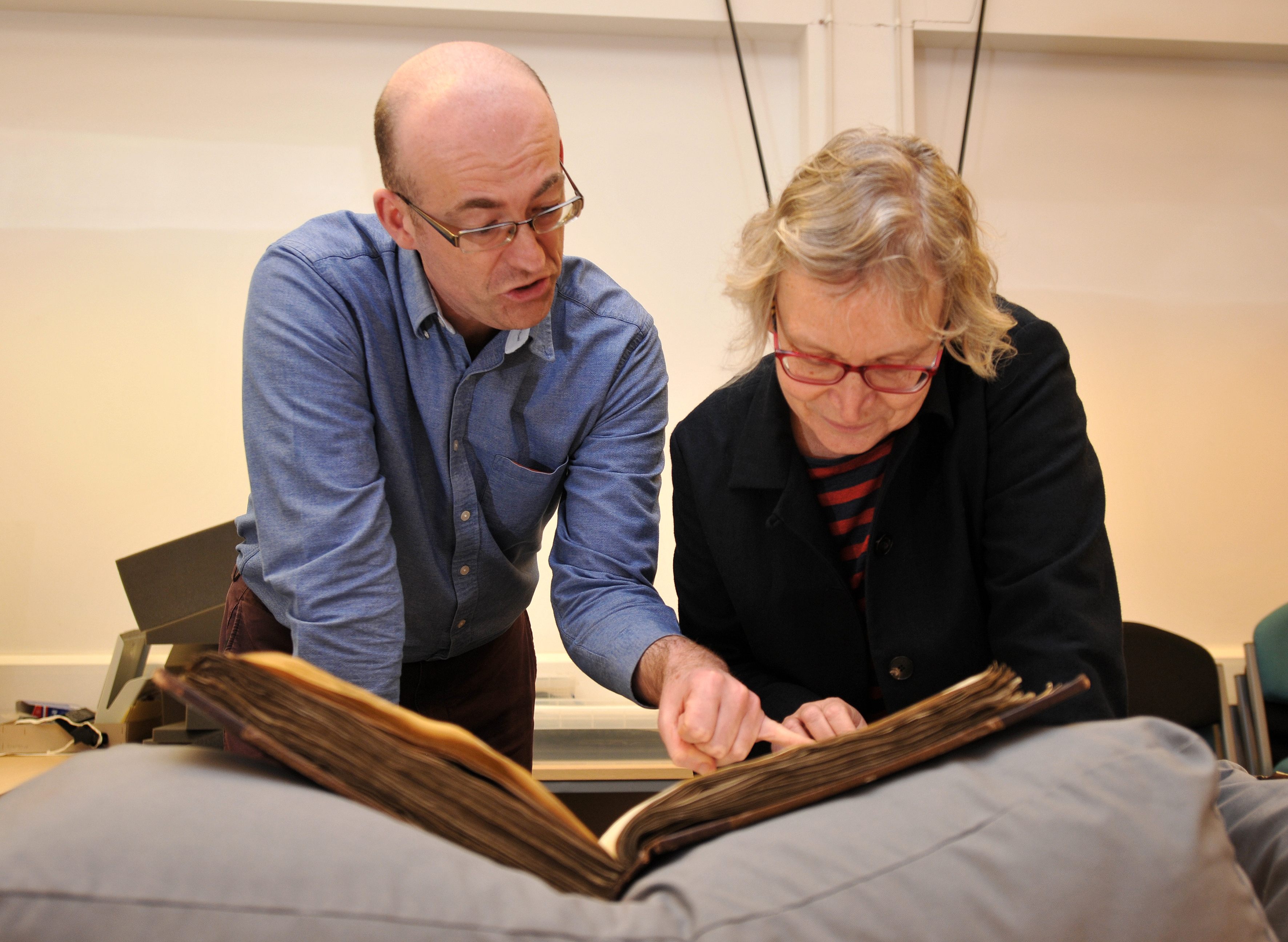 Dr. Paul Dryburgh and Professor Sarah Rees-Jones examining the 14th-century register.