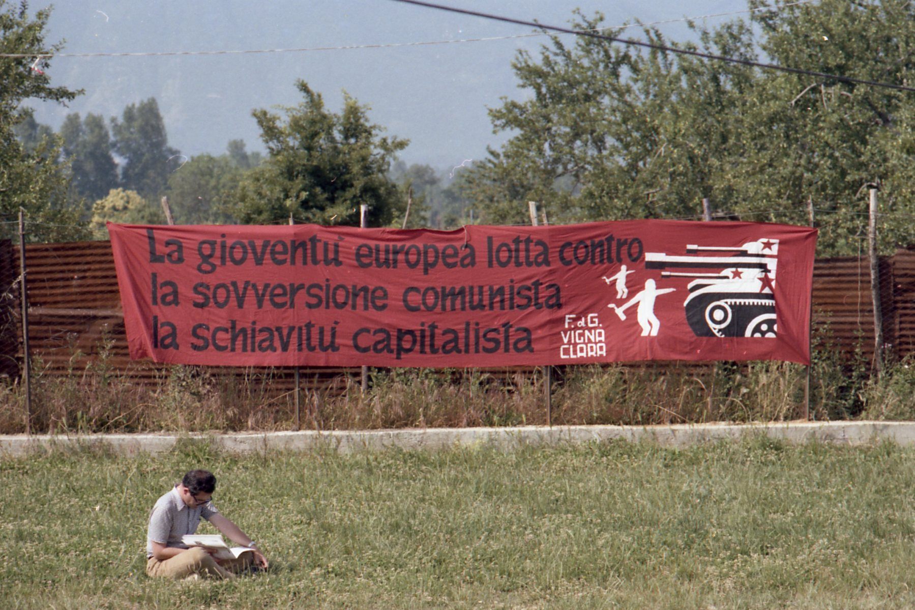 A sign at Camp Hobbit reads, "European youth fight against / communist subversion / capitalist slavery." Camp Hobbit attendees saw themselves as staking out a "third position" in Italian politics beyond right and left.