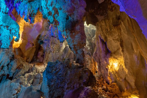 Tham Nang Ene Cave lit up with colorful neon lights.
