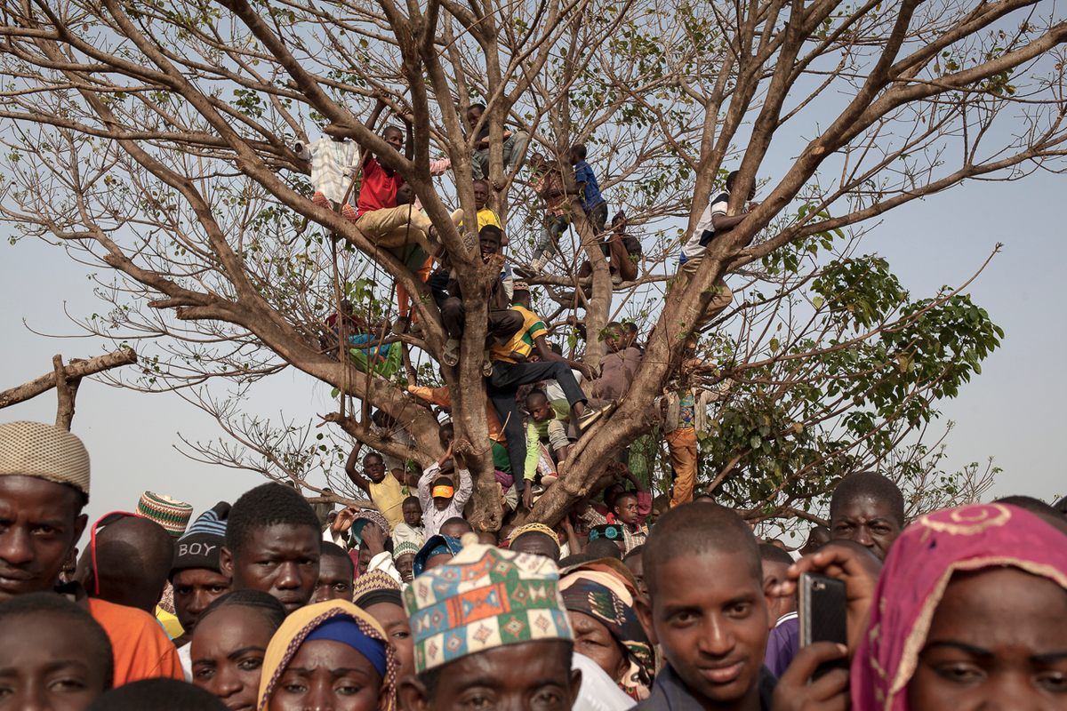 In a public space outside the Lamido, a crowd from Galim-Tignère and nearby villages watches the ceremonies.